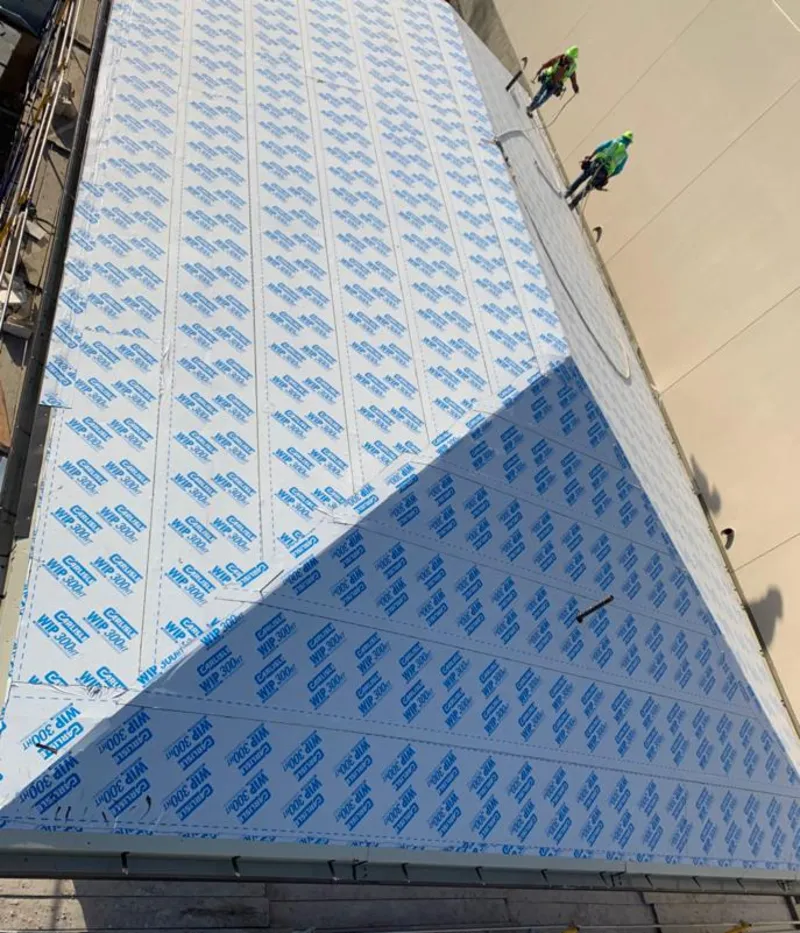 Professional roofers installing underlayment on a metal roof in Oneonta